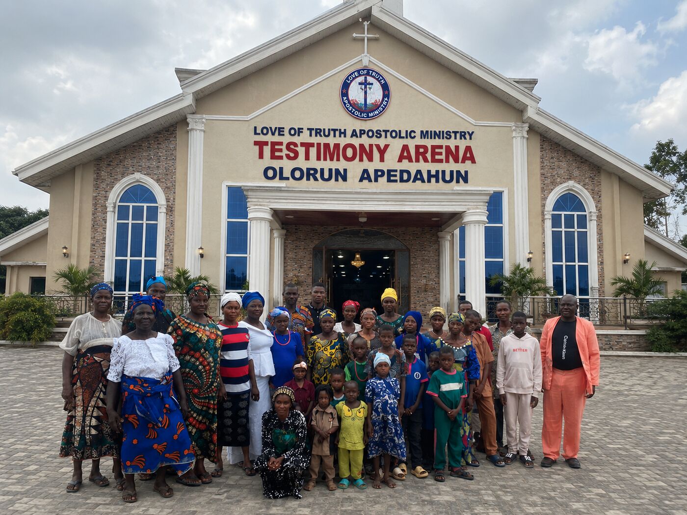 Members of Love of Truth Apostolic Ministry standing together outside the church building